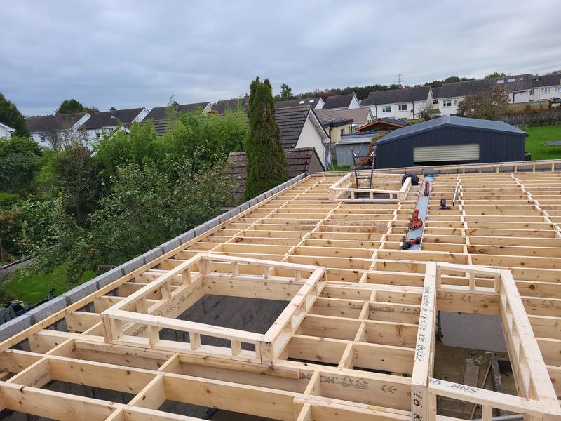 Flat roof joists on an extension with two framed openings for rooflights