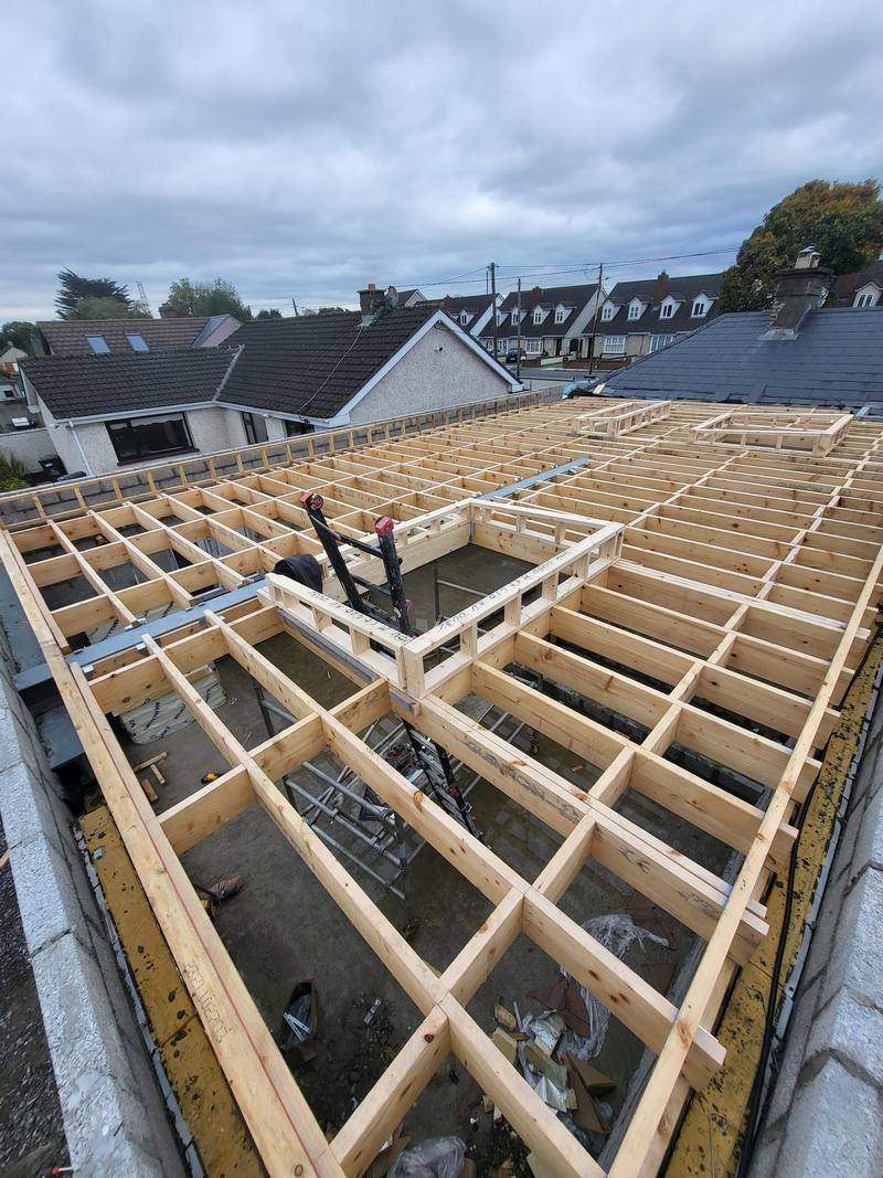 Looking along the joists of a large flat roof extension, with the room below still open